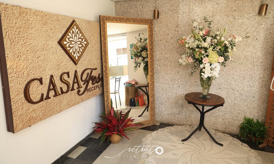 Entrada da Casa Fest com espelho dourado e flores